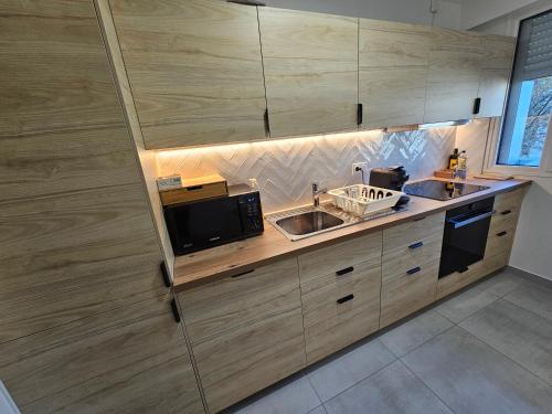 une cuisine avec un évier et un micro-ondes dans l'établissement Argenteuil 8 min Paris Centre, à Argenteuil