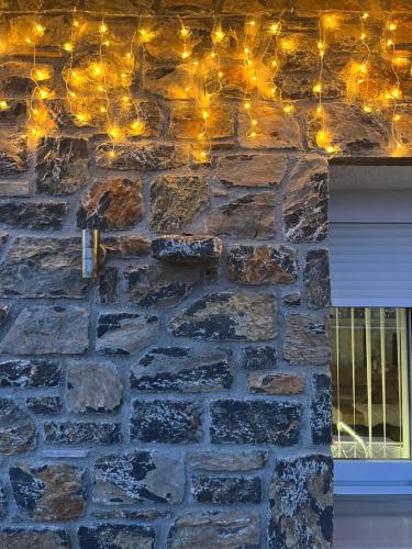 a stone wall with christmas lights on it at The Small Mountain house in Séta