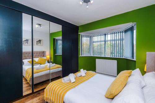 a bedroom with two beds and green walls at The Lyme Lounge - Elegant & Contemporary 3BR Home - Sleeps 7 with Parking & WiFi - Ideal for Business Stays by Parydise Properties in Longport
