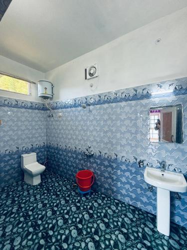 a blue and white bathroom with a sink and a toilet at Himalayan Canvas khajjiar in Khajjiar 