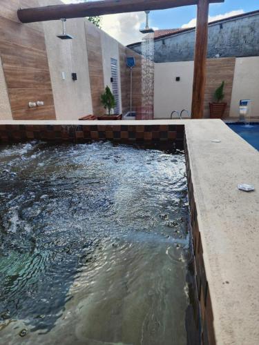 a pond in a backyard with a swimming pool at Pousada e Restaurante o Portuga in São Miguel dos Milagres