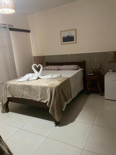 a bedroom with a bed with towels on it at Pousada e Restaurante o Portuga in São Miguel dos Milagres