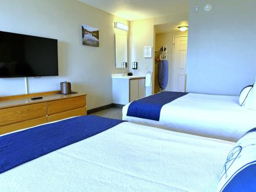 a hotel room with two beds and a flat screen tv at Atlantic Eyrie Lodge in Bar Harbor