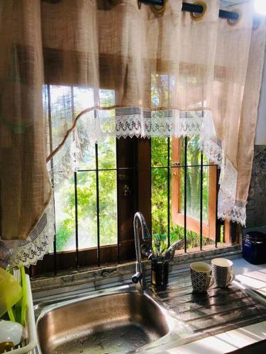 a kitchen sink with a window in a kitchen at Koshi's Country Cottage Ella in Ella