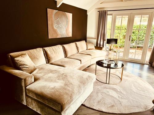 a living room with a couch and a table at Luxe chalet Beekbergen nl in Beekbergen