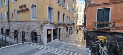 an empty alley in a city with buildings at Albergo San Marco in Venice