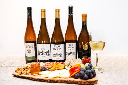 a group of bottles of wine and a plate of food at Solar das Bouças by Quantique in Amares