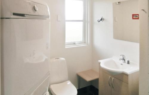 a white bathroom with a toilet and a sink at Stunning Home In Idestrup With Wifi in Marielyst