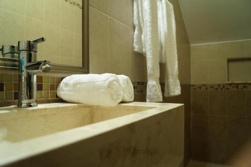La salle de bains est pourvue d'un lavabo et d'une serviette. dans l'établissement Hotel Casa Palomino, à Mérida