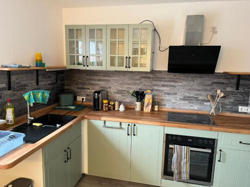 a kitchen with white cabinets and a sink at HofamHohlebach in Neuenburg am Rhein
