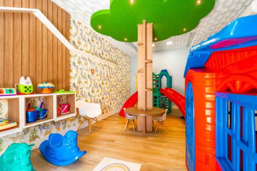 a play room with a toy house and a slide at Boulevard Beach Canasvieiras Hotel in Florianópolis
