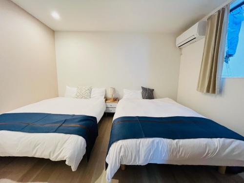 two beds sitting next to each other in a room at Year-end promotion 2 Gread location 1min to Station Closs Ueno Max 6 people Wi-fi unlimited in Tokyo