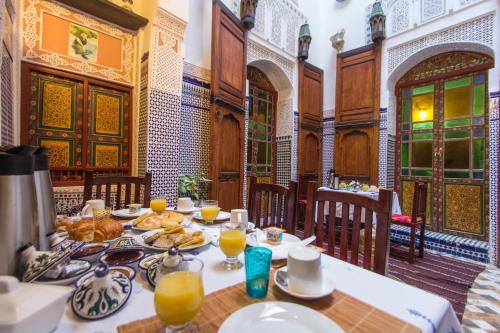 a dining room with a table with food on it at Casa Aya Medina in Fès