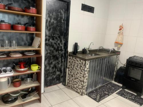 a kitchen with a sink and a stove at kit aconchego in Ubatuba
