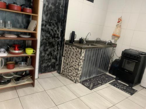 a kitchen with a sink and a stove at kit aconchego in Ubatuba