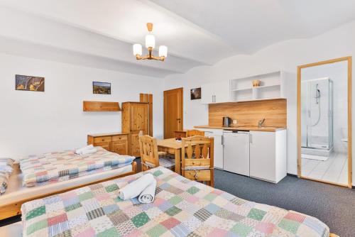 a hotel room with two beds and a kitchen at Pension Dita - Adršpach in Teplice nad Metují