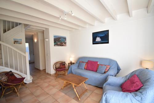 un salon avec deux canapés bleus et une table dans l'établissement Clos du lac - Hossegor agréable villa patio au calme donnant sur deux terrasses est et ouest, à Soorts-Hossegor