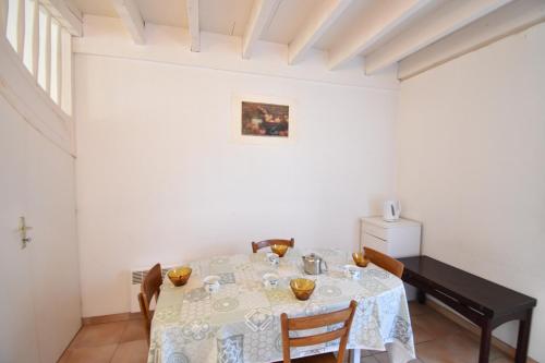 une salle à manger avec une table et un piano dans l'établissement Clos du lac - Hossegor agréable villa patio au calme donnant sur deux terrasses est et ouest, à Soorts-Hossegor
