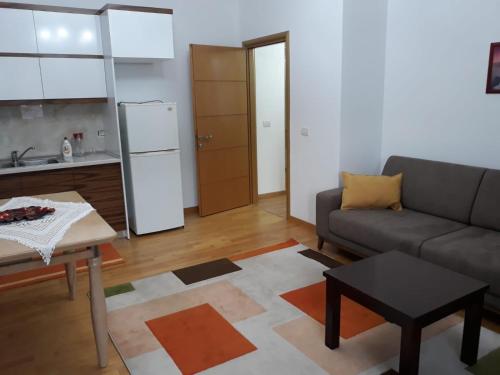 una sala de estar con un sofá y una mesa en Pere's Holiday Apartament, en Pogradec