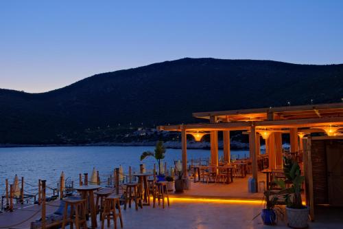a group of tables and chairs next to a body of water at Lures Hotel in Kalkan