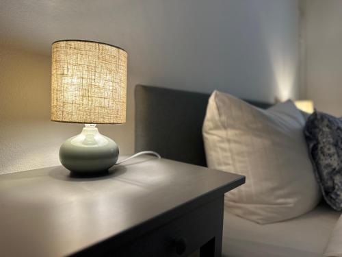 a lamp sitting on a table next to a bed at Historisches Eckermannhaus - Apartments in Weimar
