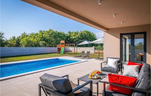 een patio met stoelen, een zwembad en een tafel bij Villa Vitis Vitae in Peresiji