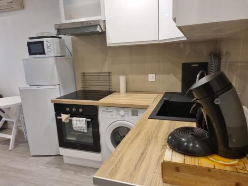 une cuisine avec une machine à laver sur un comptoir dans l'établissement Appartement f2 au bord de mer, à Saint-Raphaël