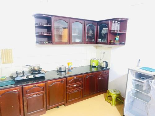 a kitchen with wooden cabinets and a stove top oven at Mangosteen villa in Ernakulam
