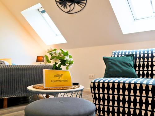a living room with two chairs and a table with a box at Studio en plein centre de Saint-Omer - à 5 min de la gare, parking gratuit in Saint-Omer