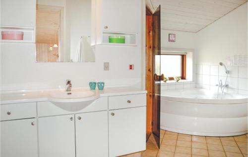 a white bathroom with a tub and a sink at Holiday Home Klitsvinget Ringkøbing Ii in Klegod