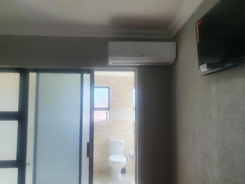 a bathroom with a white toilet in a room at Arrival Center BnB in Maseru