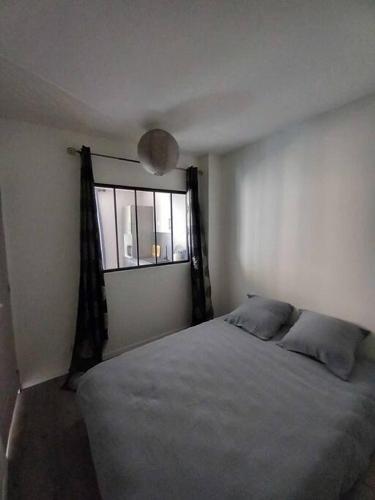 une chambre avec un lit et une fenêtre dans l'établissement Appart Distillerie, à Narbonne