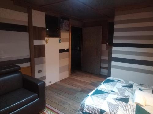 a bedroom with a bed and a chair in a room at Cabaña 79 Papallacta Alpina in Papallacta