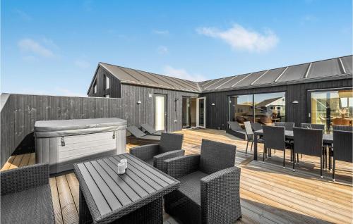 un patio avec une table et des chaises sur une terrasse dans l'établissement Awesome Home In Harboøre With Kitchen, à Harboør