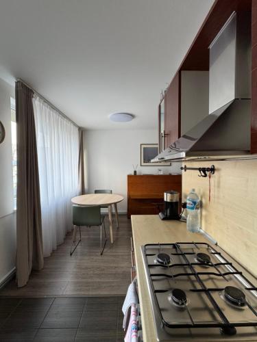 a kitchen with a stove top oven next to a table at APARTMENTS IN THE CITY CENTER BIRŽAI Vytauto g22 in Biržai