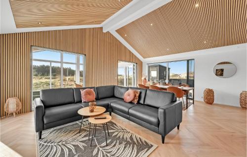 un salon avec un canapé noir et une table dans l'établissement Awesome Home In Harboøre With Kitchen, à Harboør