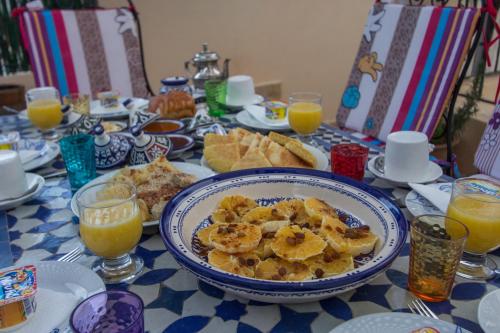 a table with a plate of breakfast food and orange juice at Casa Aya Medina in Fès