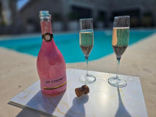 two glasses of champagne on a table next to a pool at Villa Aurelia Privat Pool in Kolimbia