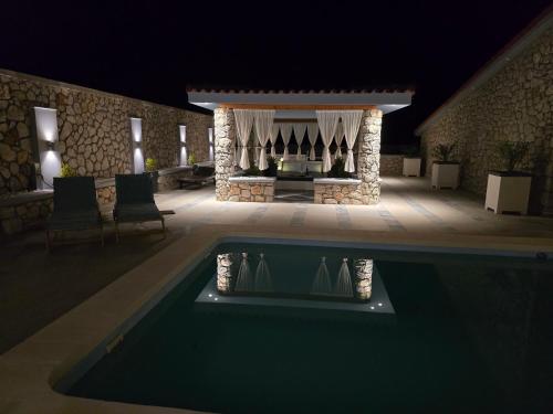 a swimming pool in front of a house at night at Villa Aurelia Privat Pool in Kolimbia