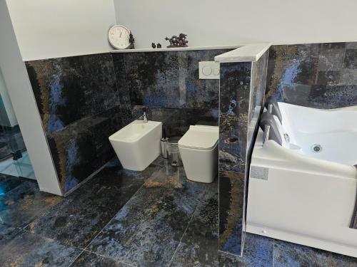 a bathroom with a sink and a tub and a toilet at Villa Aurelia Privat Pool in Kolimbia