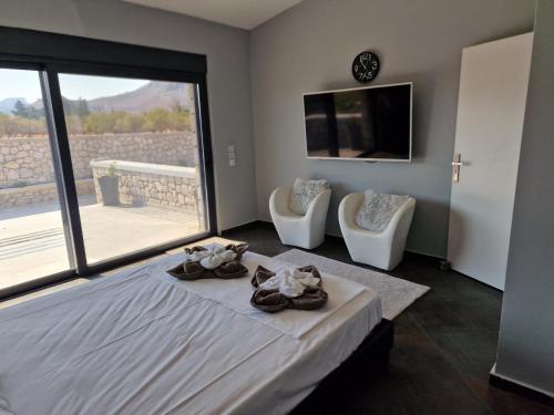 a bedroom with a bed and two chairs and a television at Villa Aurelia Privat Pool in Kolimbia