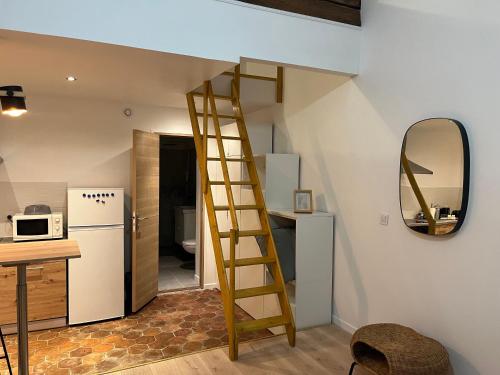 - une cuisine avec une échelle à côté d'une cuisine équipée d'un réfrigérateur dans l'établissement La Petite Bourgeoise, à Croisilles