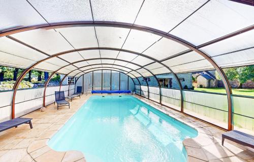 an indoor swimming pool with an arched ceiling at Awesome Home In Rubercy With Sauna in Rubercy