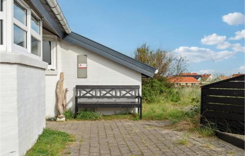 a white building with a gate and a brick driveway at Pet Friendly Home In Thisted With Wifi in Torsted