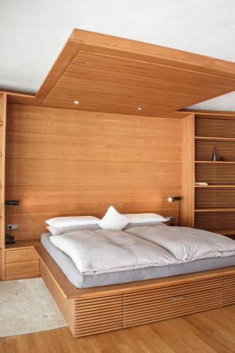 a bedroom with a large bed with a wooden headboard at Turm Chalet in Laces