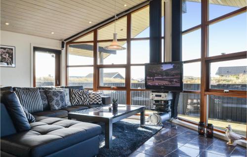 a living room with a couch and a tv at Holiday Home Arvidvej Hvide Sande Denm in Bjerregård