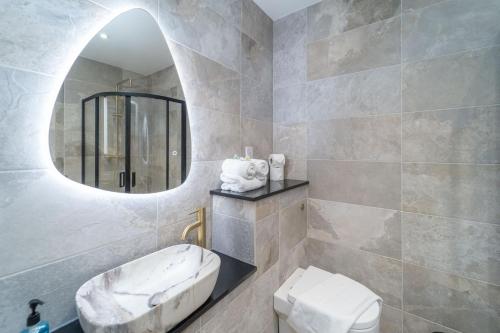 a bathroom with a sink and a mirror and a toilet at Bankton Rooms & Lodges in Livingston