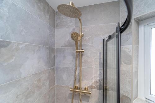 a shower with a shower head in a bathroom at Bankton Rooms & Lodges in Livingston