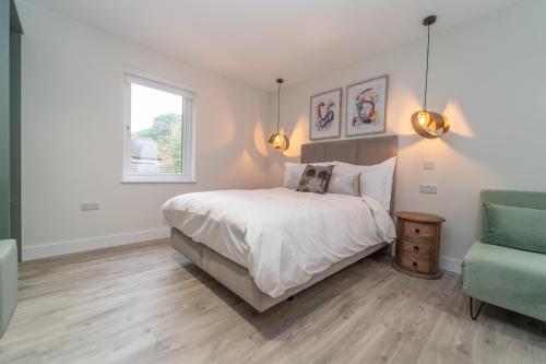 a bedroom with a bed and a green chair at Bankton Rooms & Lodges in Livingston