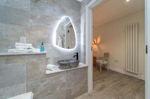 a bathroom with a sink and a mirror at Bankton Rooms & Lodges in Livingston